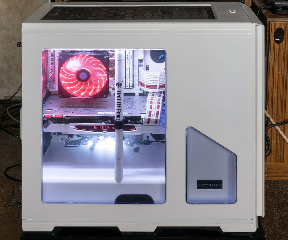 A white desktop computer tower with a windowed side panel showing red-lit cooling inside.
